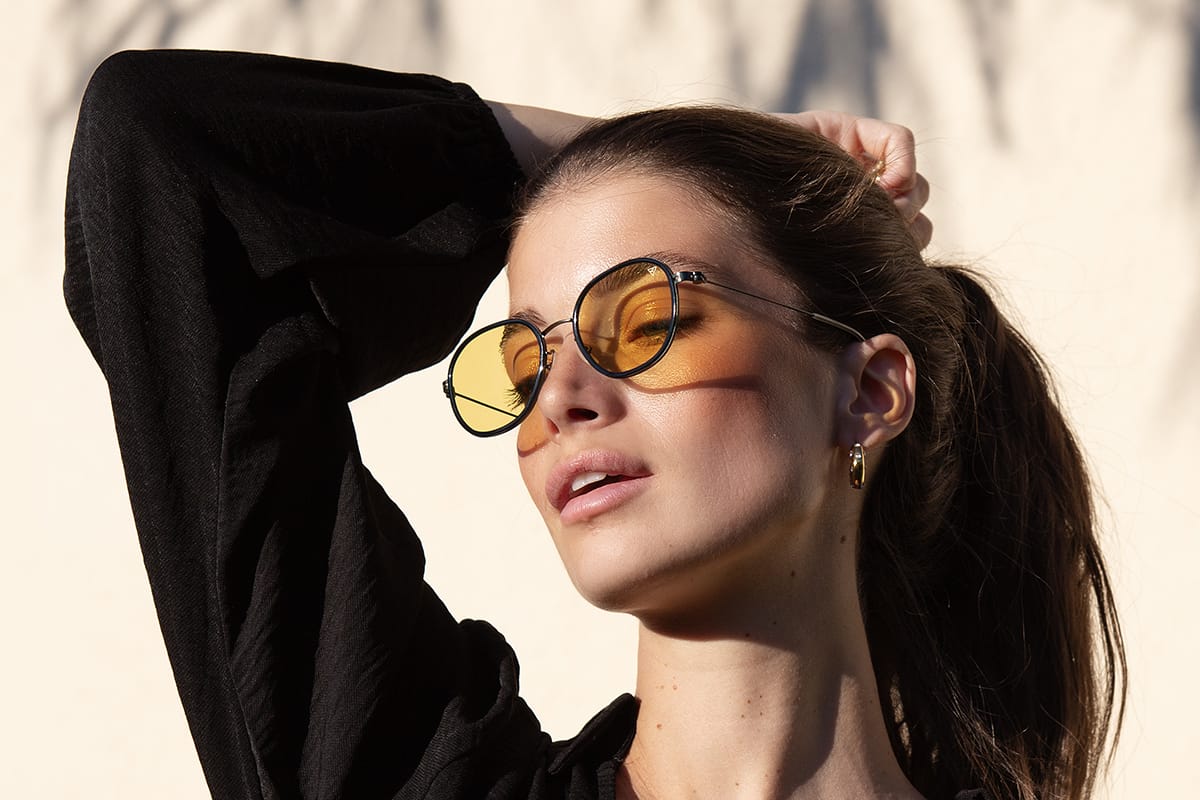 Hyperlight Optics KSA Woman wearing yellow sunglasses with a blurred background